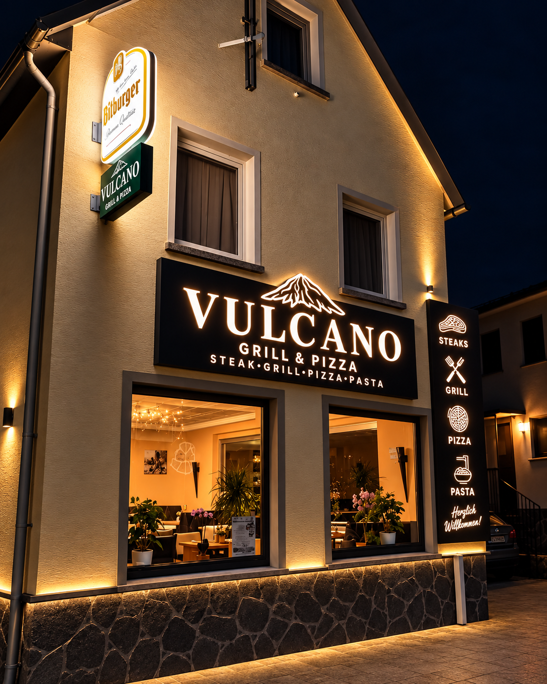 Beleuchtete Fassade von Vulcano Grill & Pizza in Ulmen